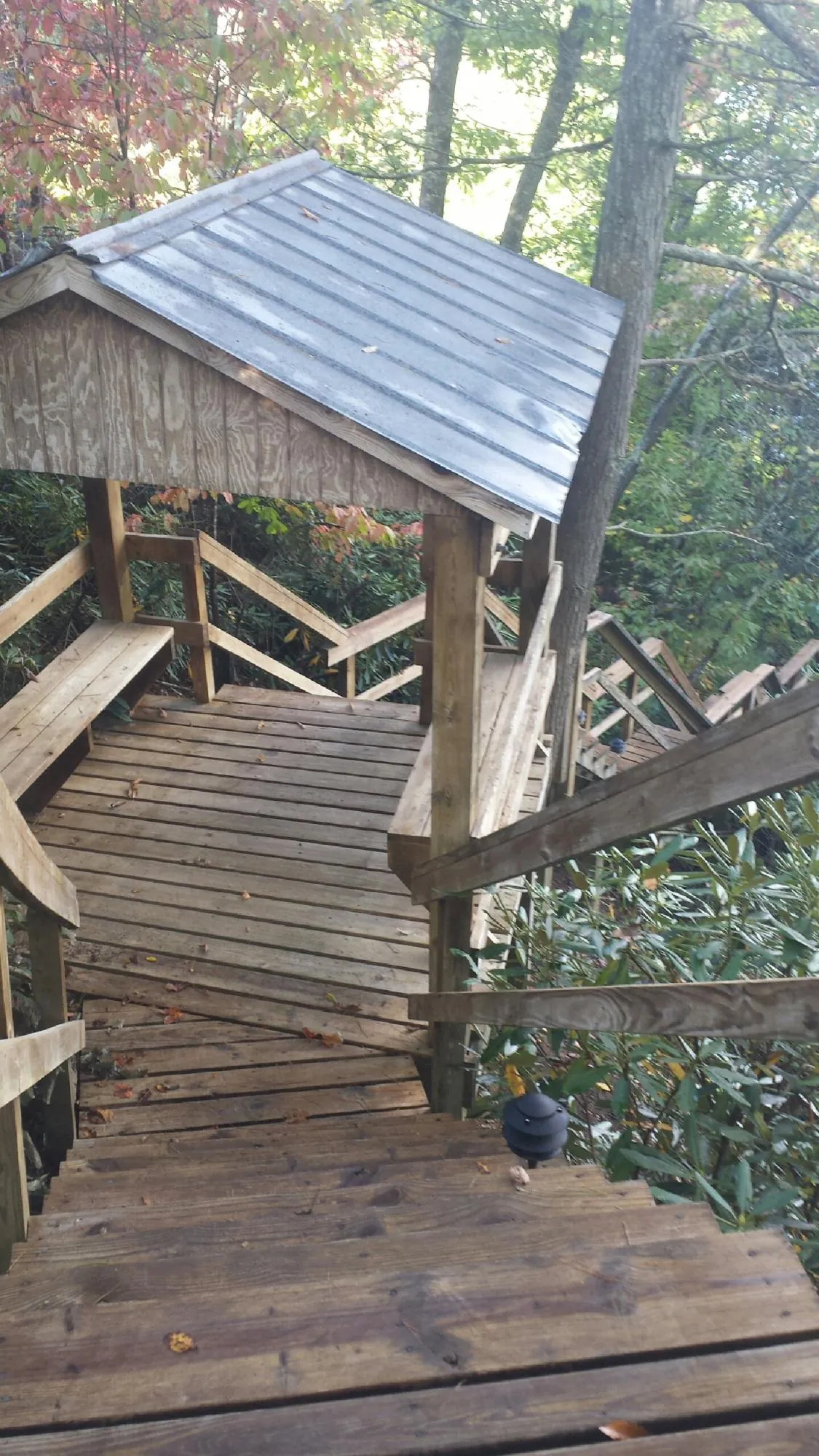 Metal roofed shelter over wooden steps on a wooded walkway — Skylight Repair & Installation work by our crew in Buckingham